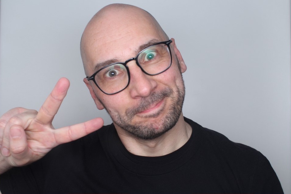 Björn Schulze making a peace sign against a plain background.