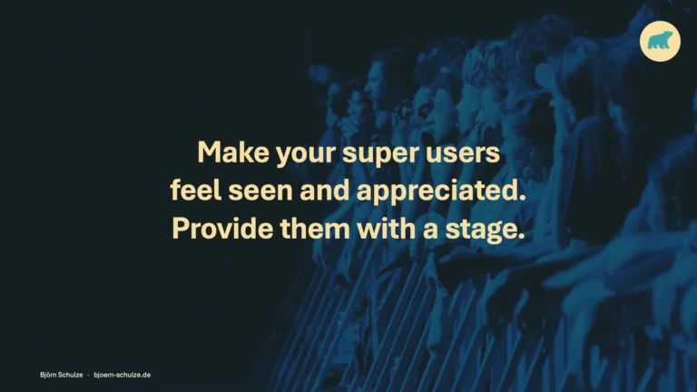 Kernaussage „Make your super users feel seen and appreciated. Provide them with a stage.“ vor einem Publikum im blauen Bühnenlicht.